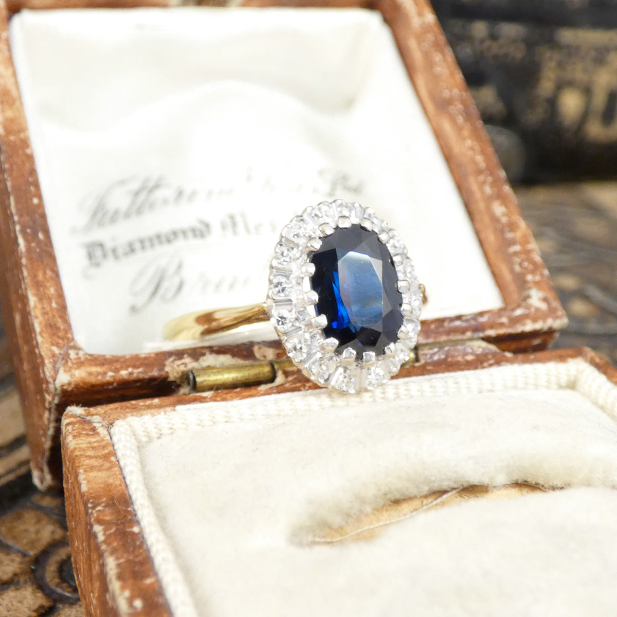 Vintage ring with a blue gemstone in an open wooden box