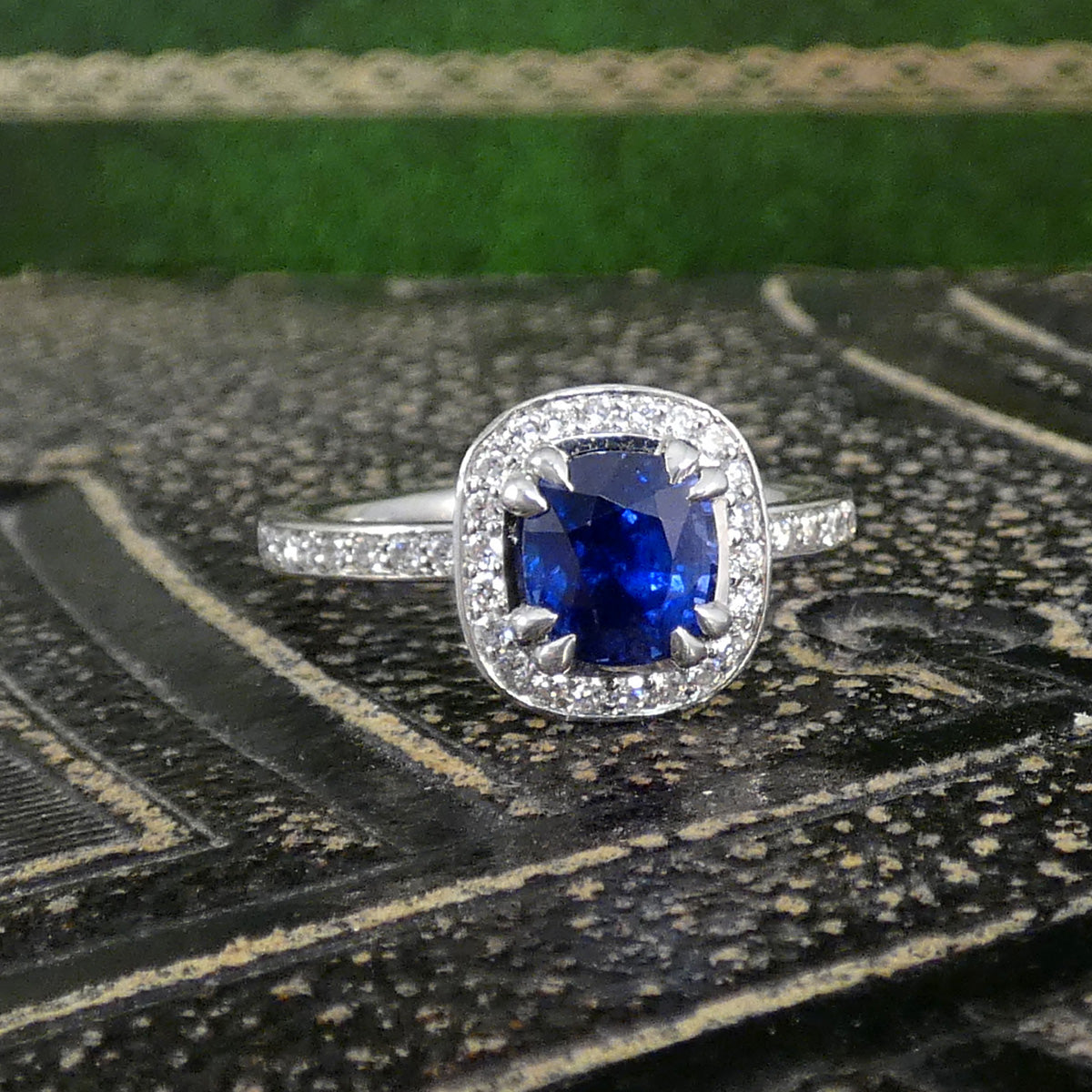 Platinum ring with a blue gemstone on a textured surface