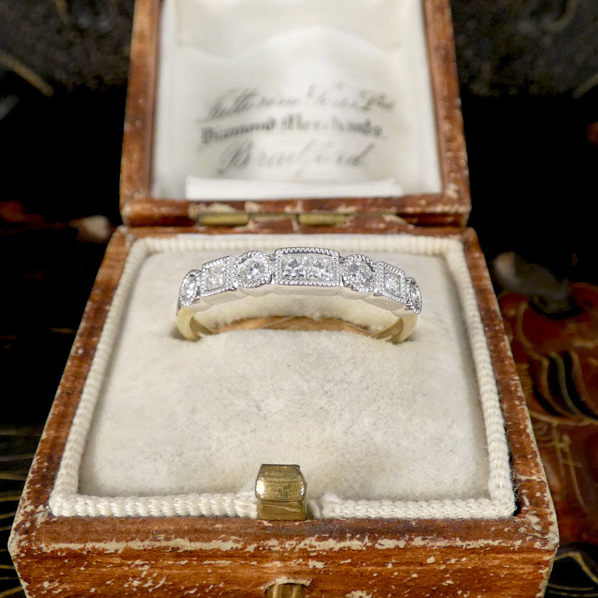 Diamond ring in an open wooden box with a visible brand name.