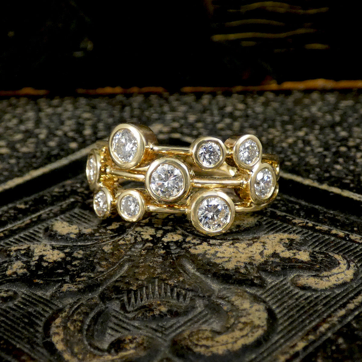 Gold ring with diamonds on a textured dark surface