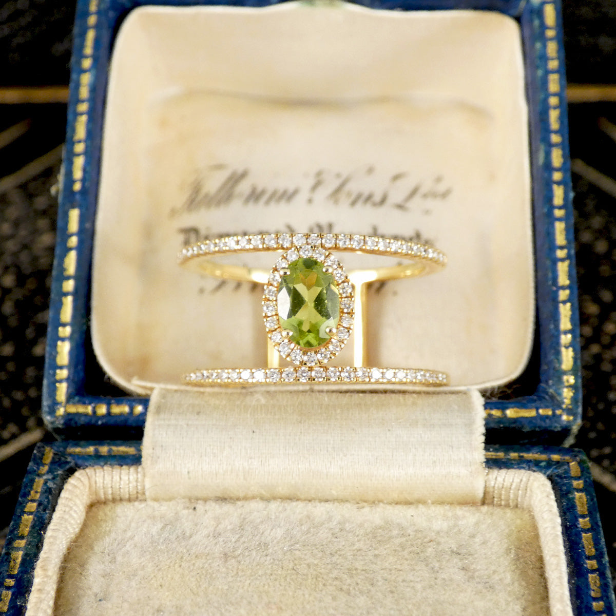 Peridot and Diamond cluster ring with diamond set spacers in 18ct white gold shown in vintage ring box
