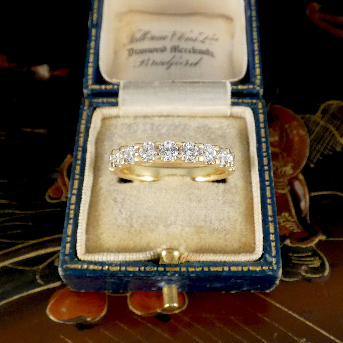 Gold ring with diamonds in a jewelry box on a decorative surface