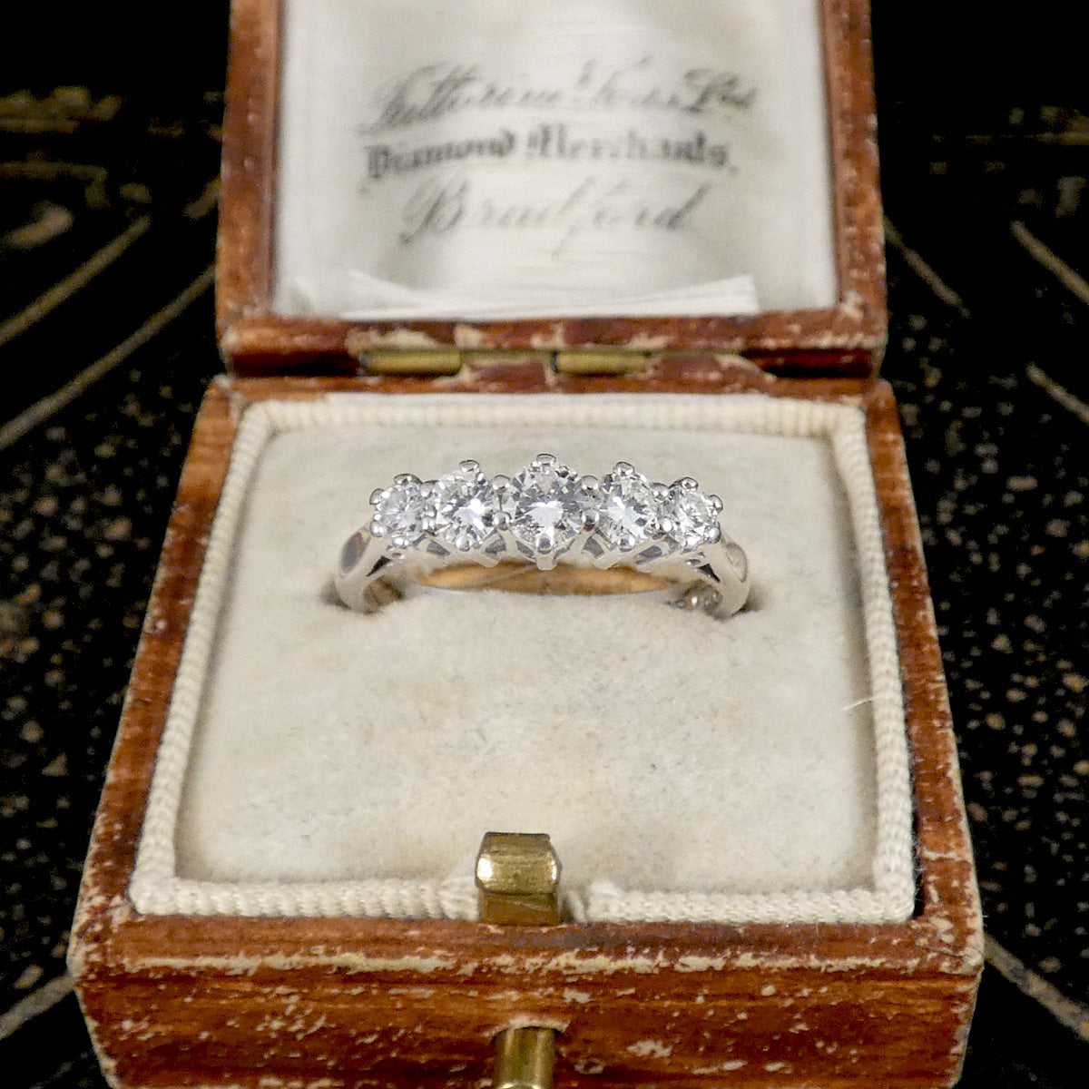 A diamond ring displayed in a vintage box
