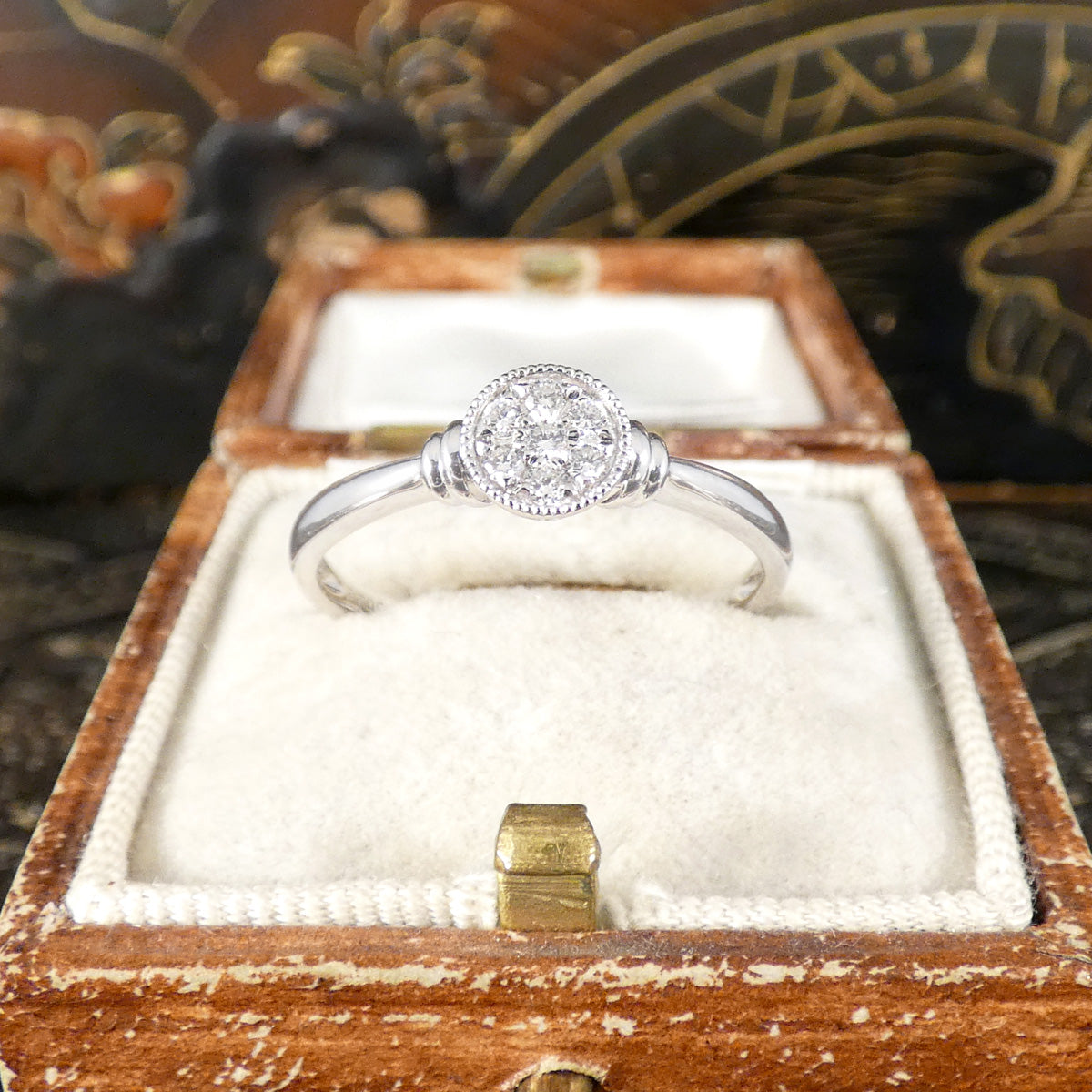 A diamond set disc shaped cluster ring with a double donut shoulders in Platinum. Displayed in vintage box.