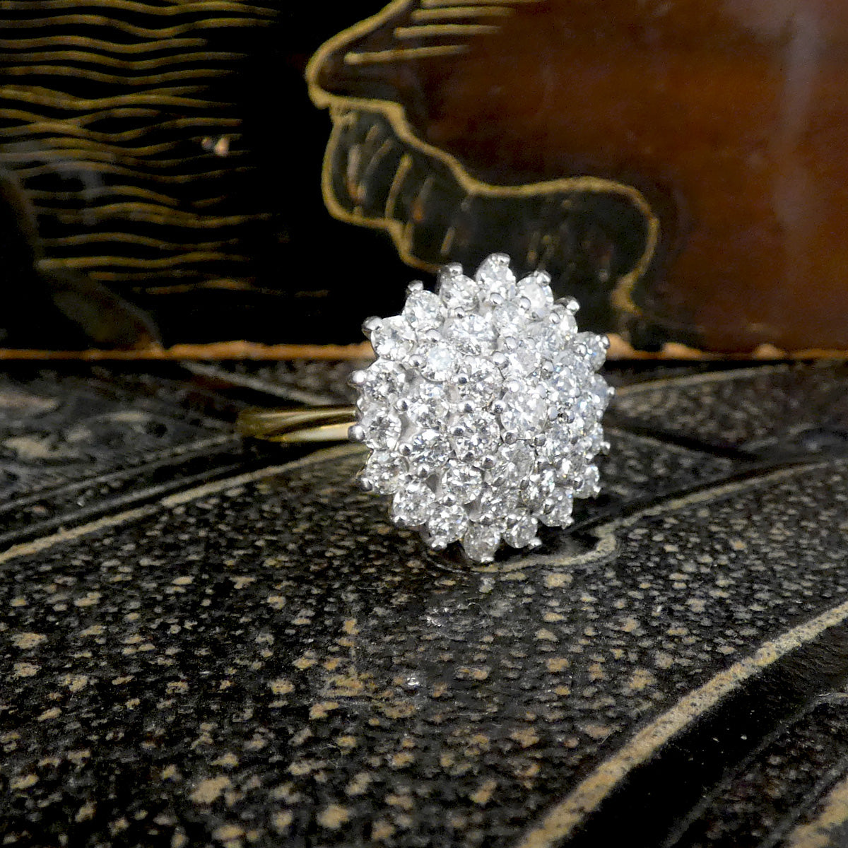 Silver ring with diamonds and gold  on a textured surface