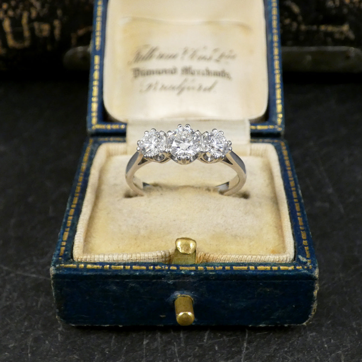 Diamond ring in an antique blue jewelry box with gold accents