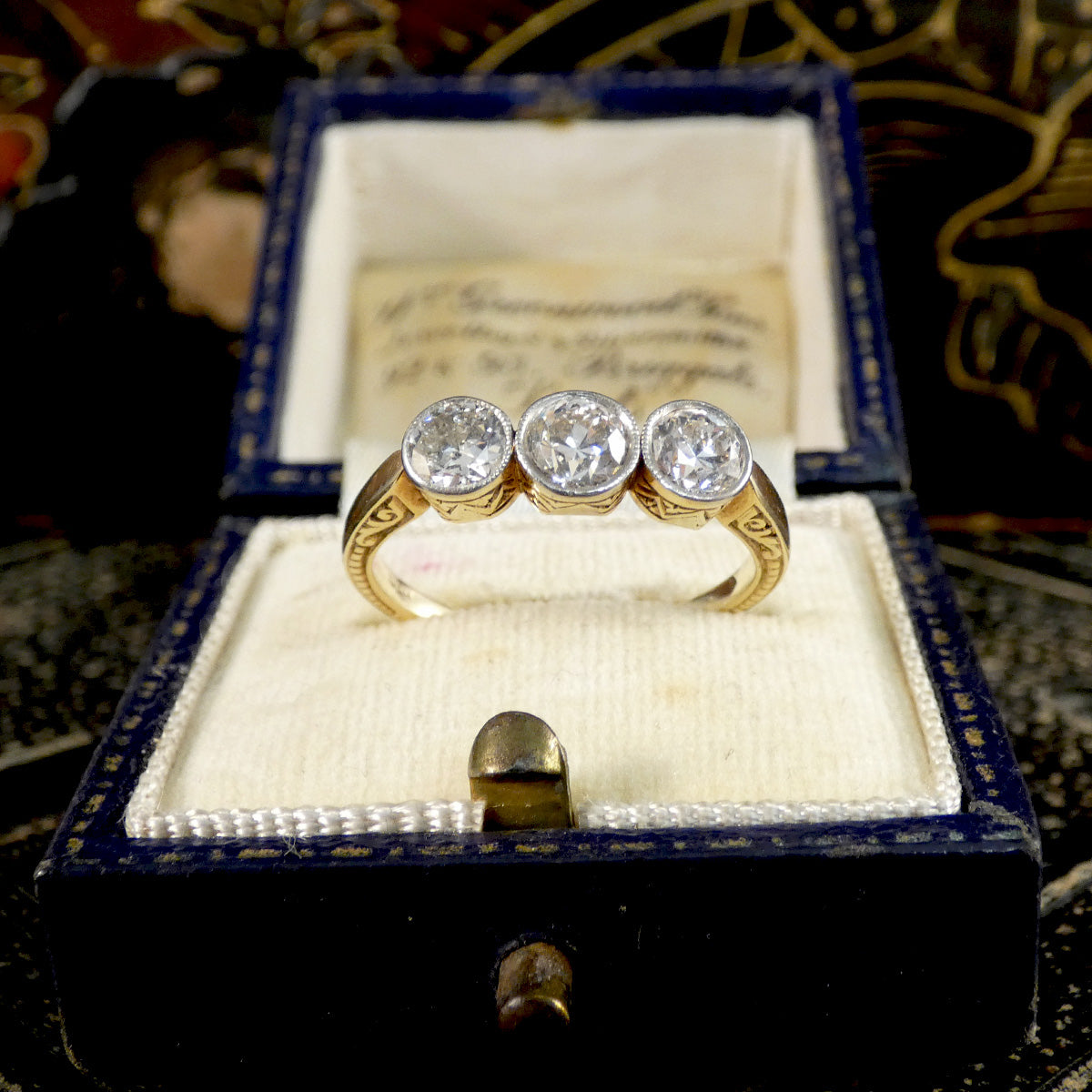 Gold ring with three diamonds in a decorative box