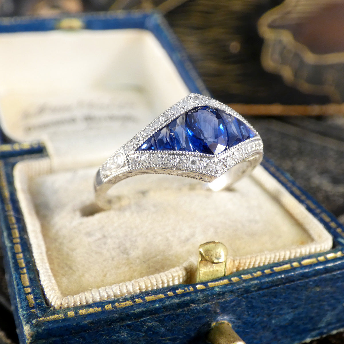 A gorgeous Art Deco style Sapphire and Diamond cluster ring in Platinum. Displayed in vintage box.