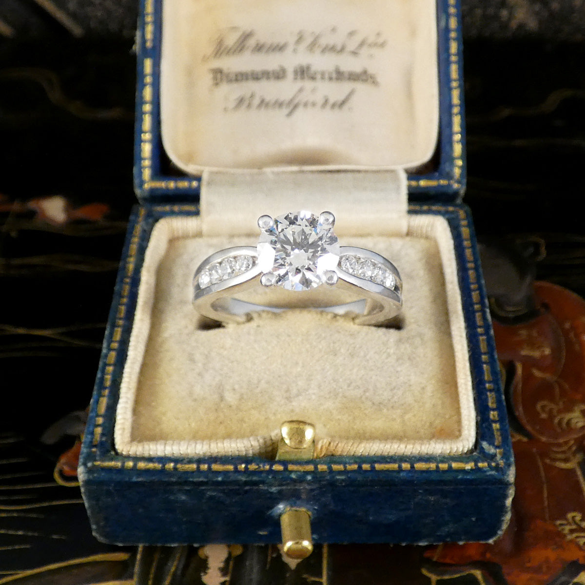Diamond ring in a blue velvet box with gold text