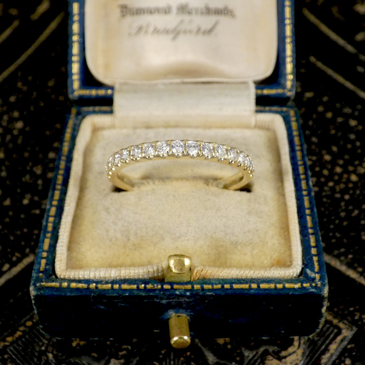 A diamond half eternity ring in yellow gold,  displayed in box