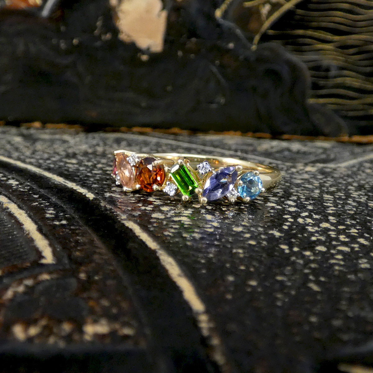 Ring with multicolored gemstones on a textured surface