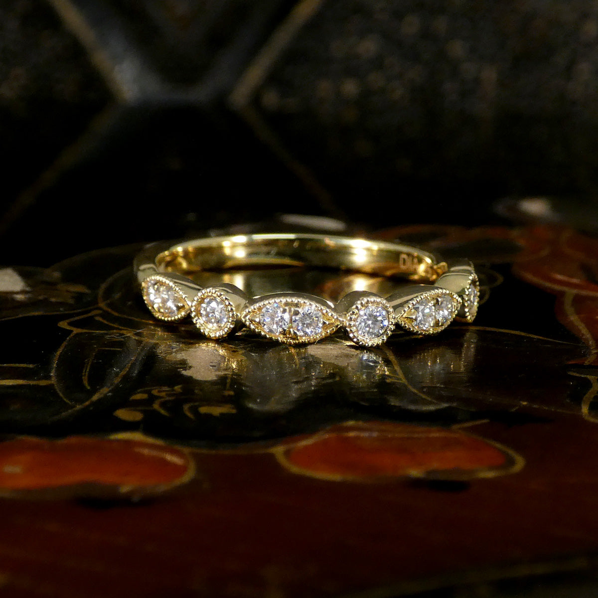 Gold ring with diamonds on a decorative surface