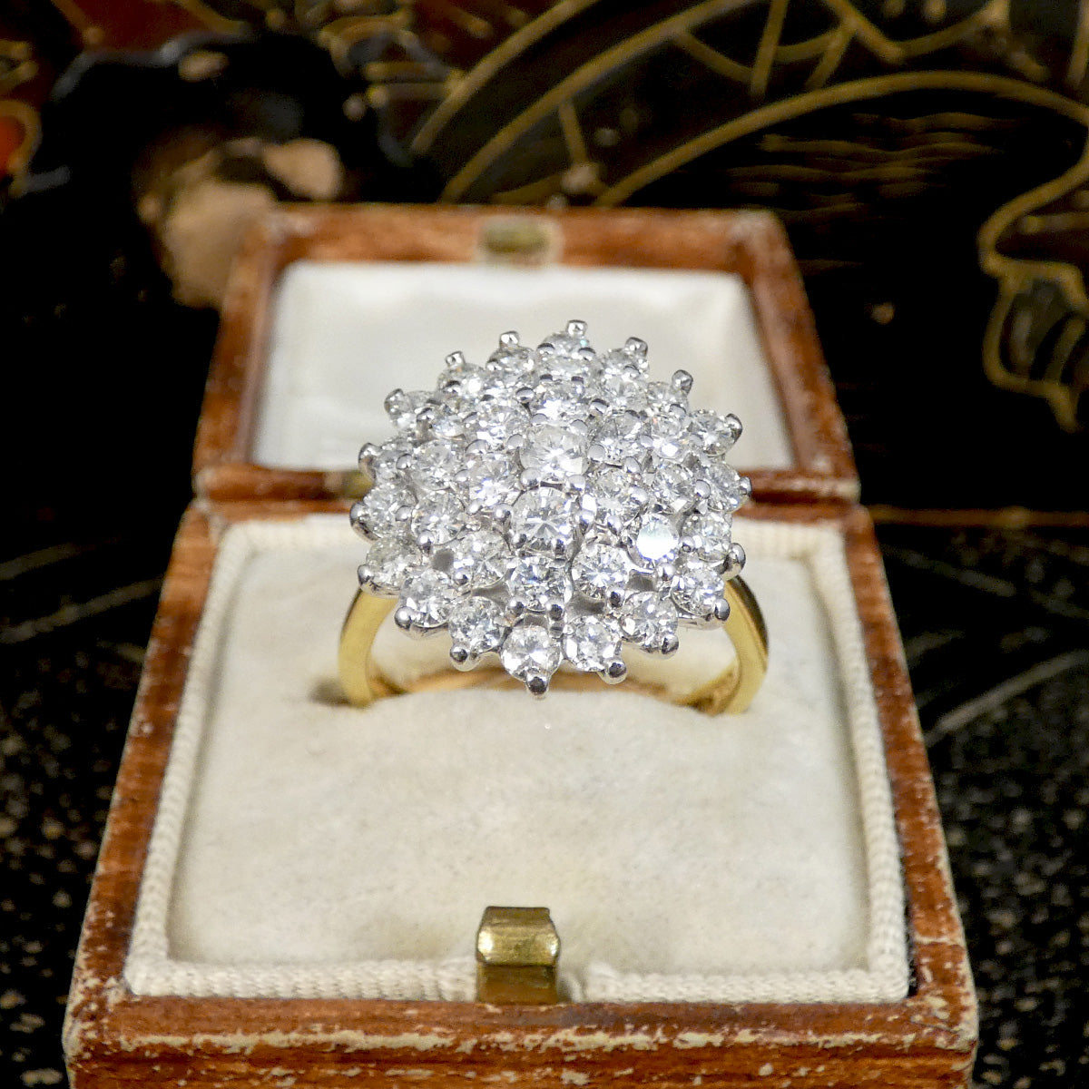 Diamond ring in a wooden box with a decorative background