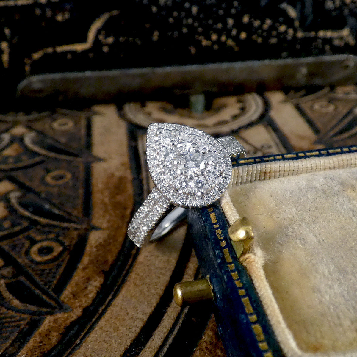 Diamond ring on an ornate surface with a vintage feel
