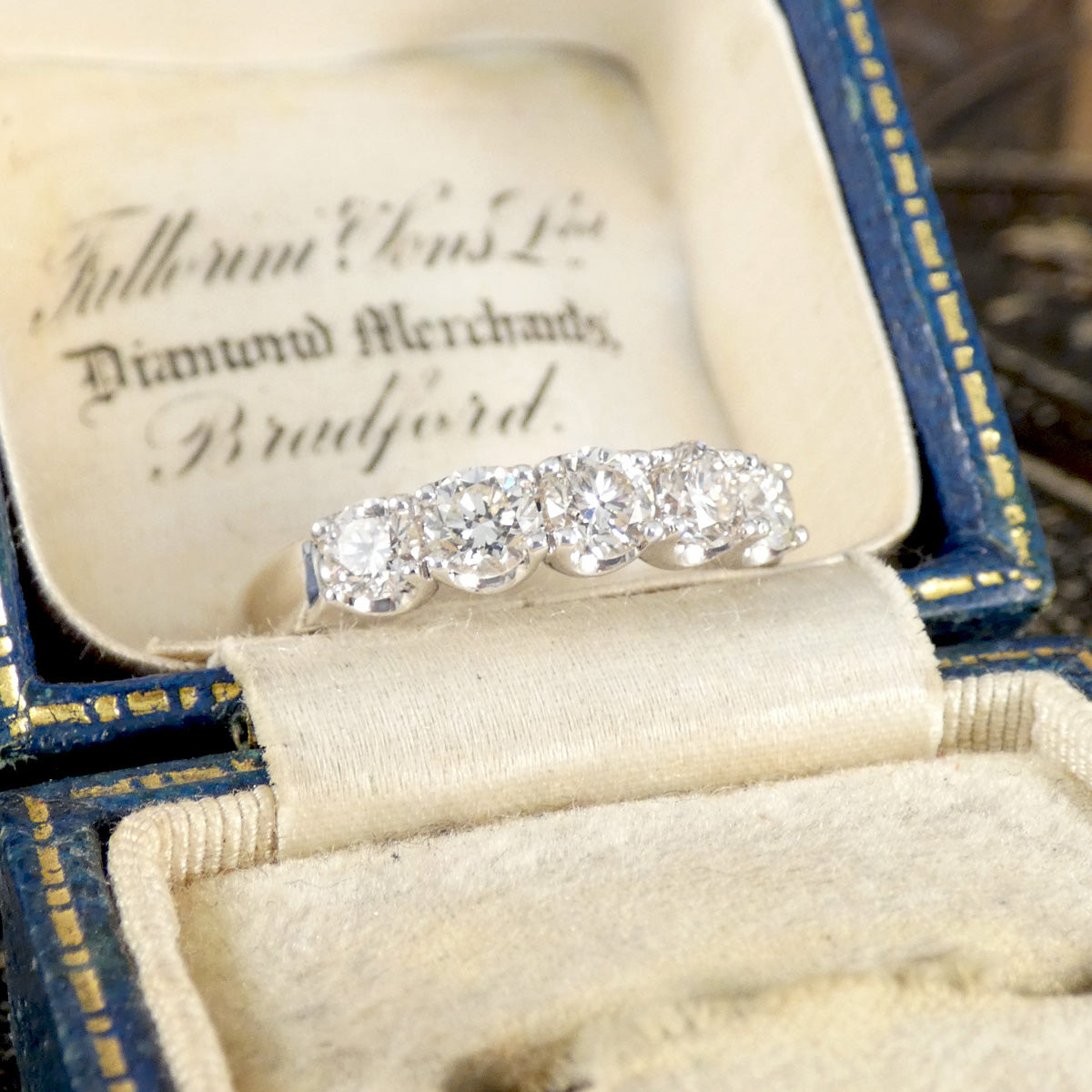 Diamond ring in an open jewelry box with visible branding