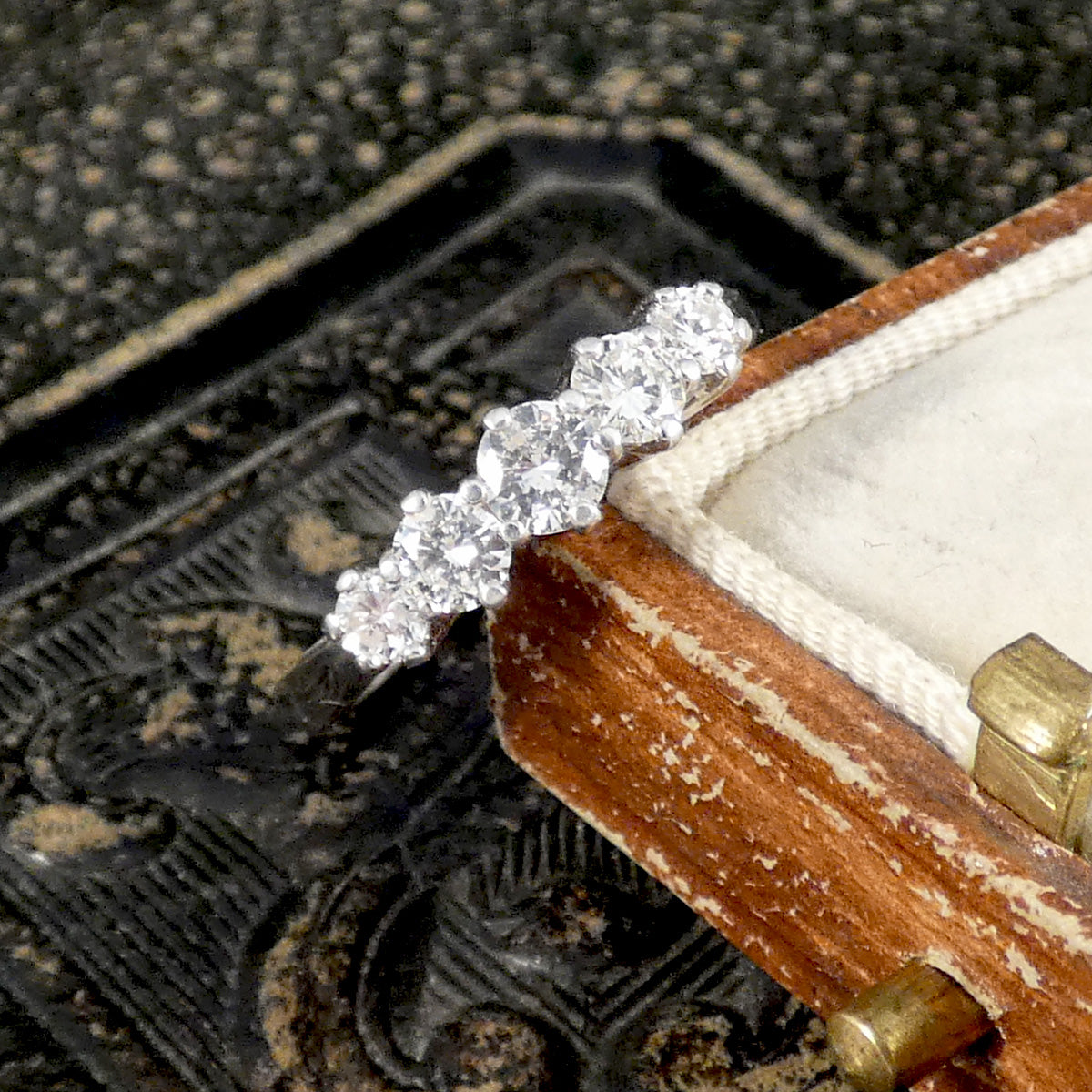 A diamond ring leaning on a vintage box