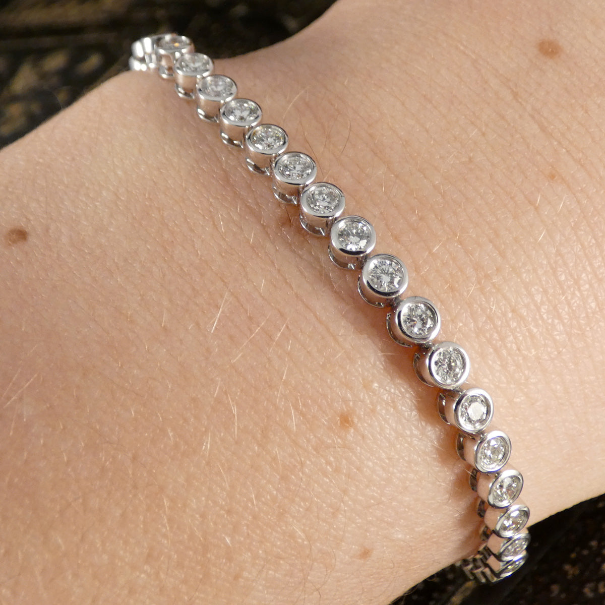 A diamond tennis bracelet in a bezel setting in Platinum