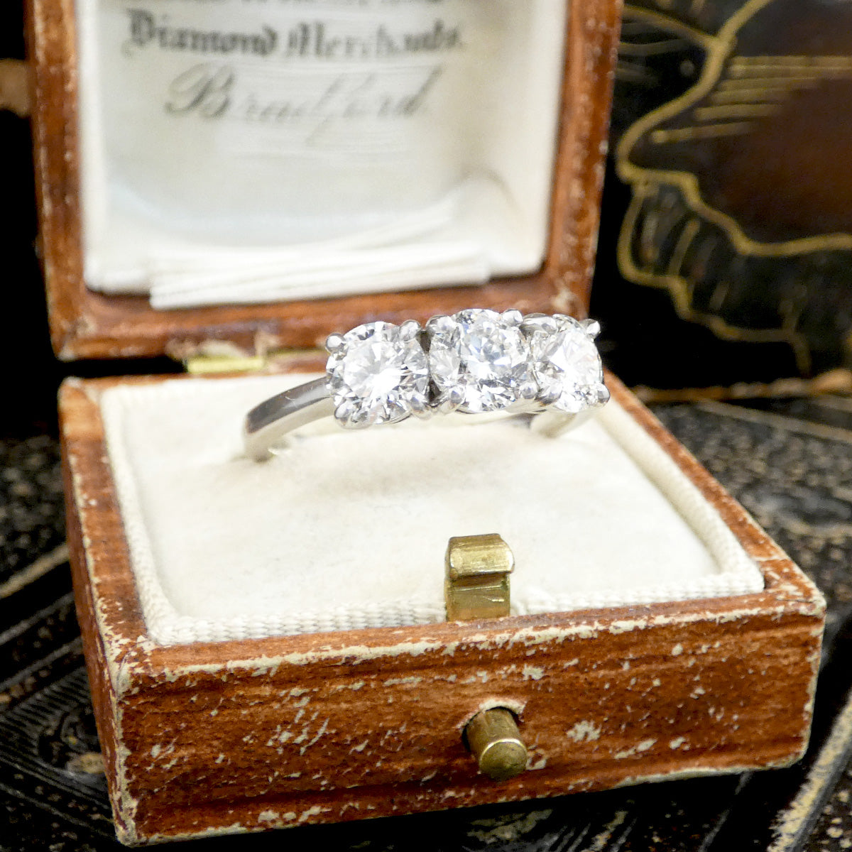Diamond ring in an open wooden box with a blurred background