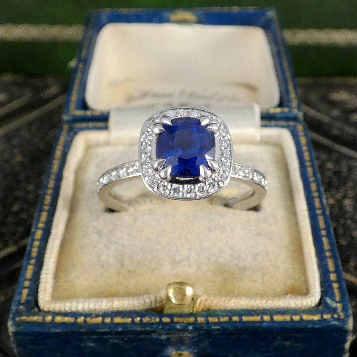 Platinum ring with a blue sapphire gemstone in a blue jewellery box