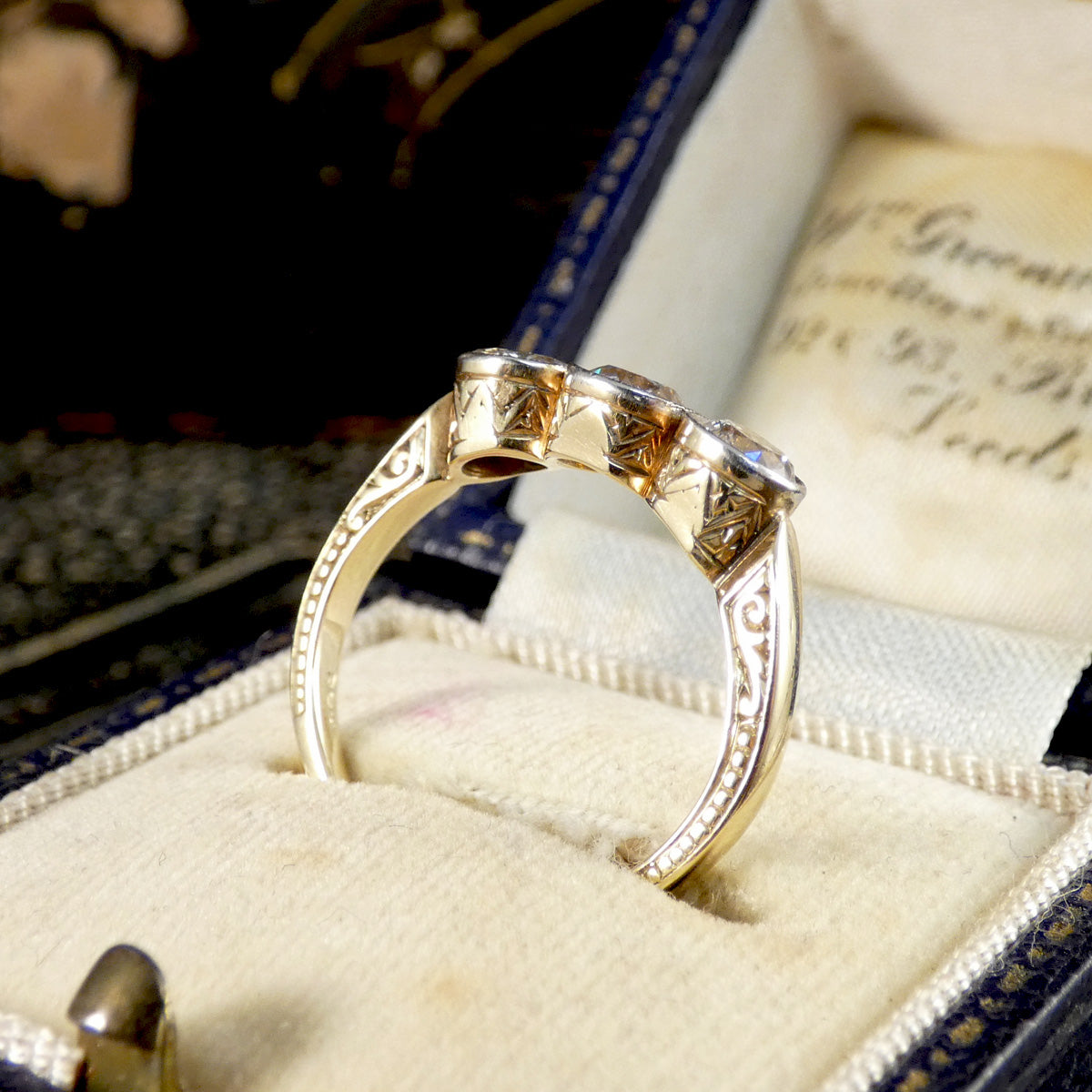 Gold ring with diamond accents in a jewelry box