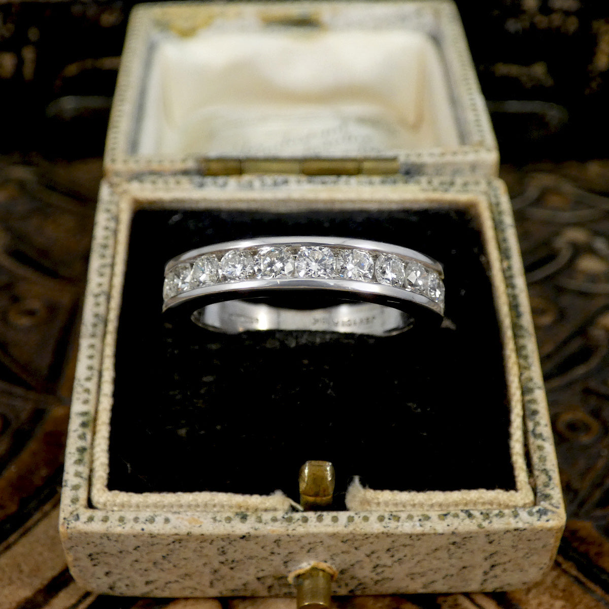 White Gold ring with diamonds in a jewellery box on a textured surface