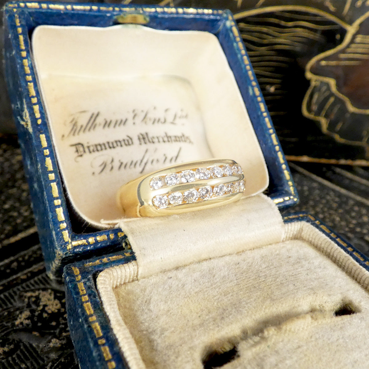 A channel set diamond double row ring in yellow gold in a vintage ring box