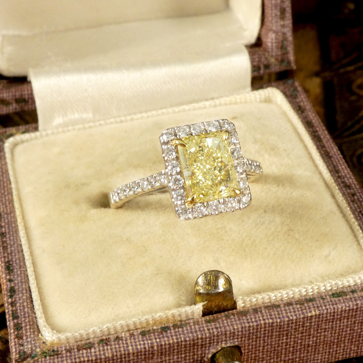 Natural Yellow Radiant Cut Diamond with GIA grading in a four claw setting. Surrounded by a halo of bright white Diamonds and Diamond set shoulders in 18ct White Gold. Perfect engagement ring.