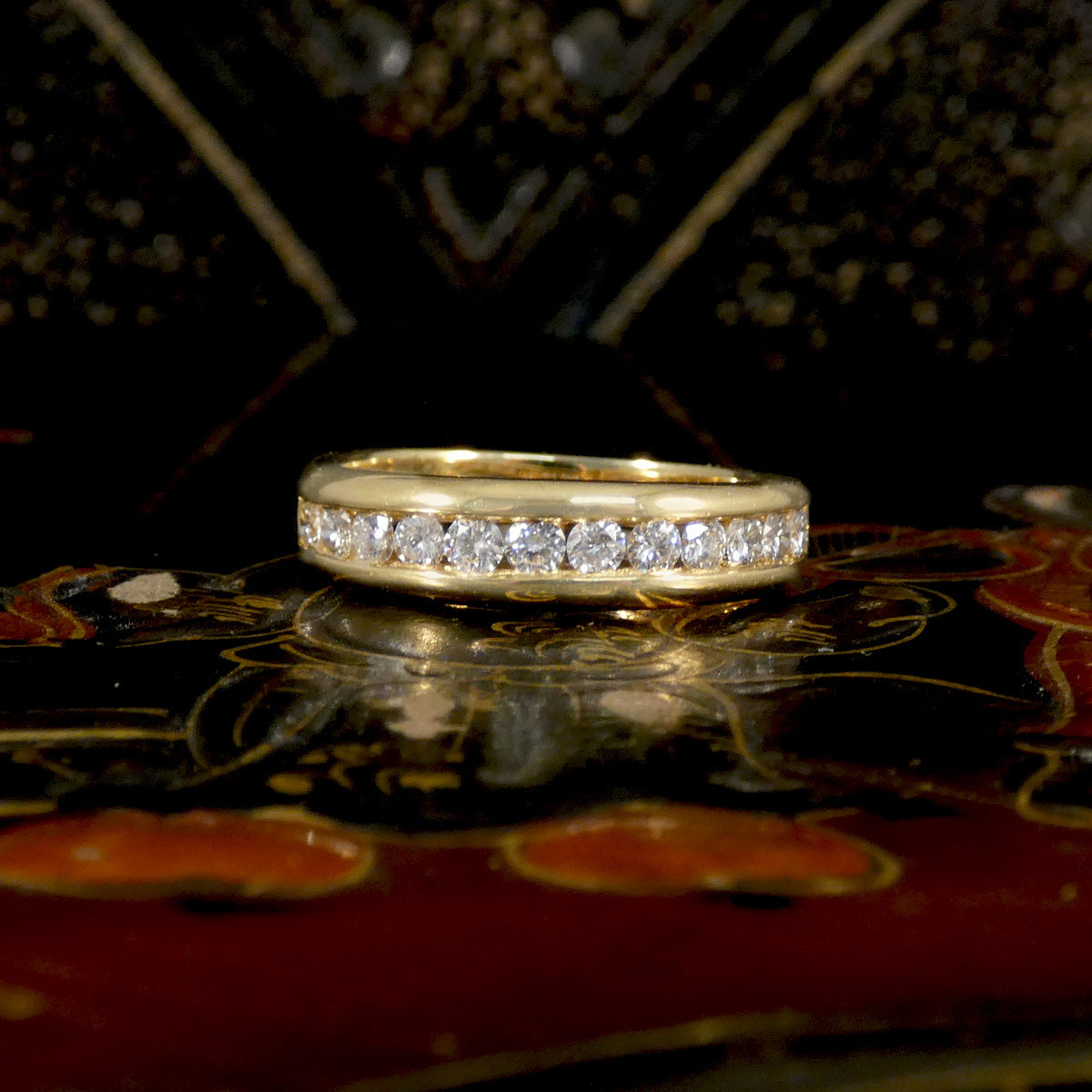 Gold ring with diamonds on a decorative surface