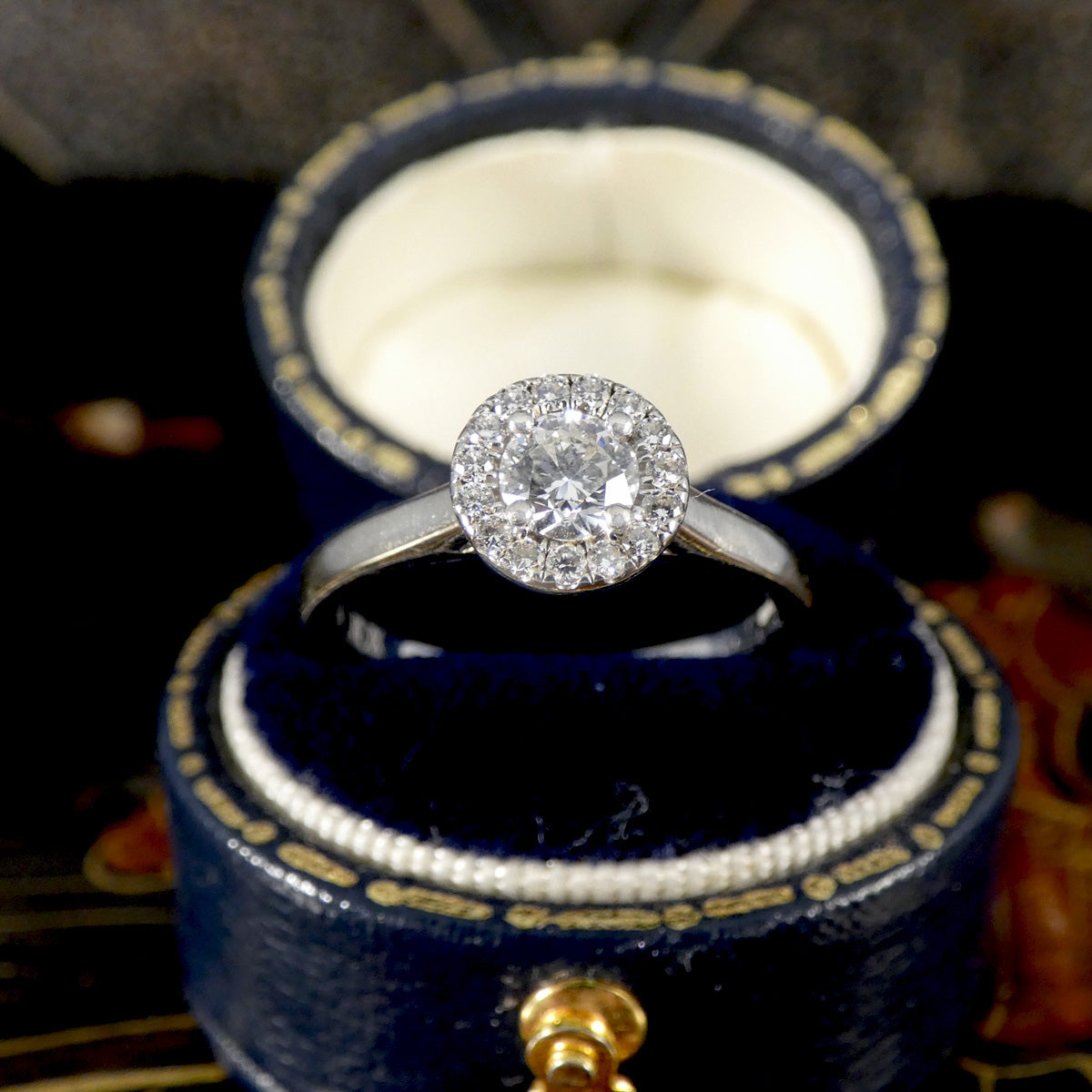 Diamond ring in a blue jewelry box with gold accents