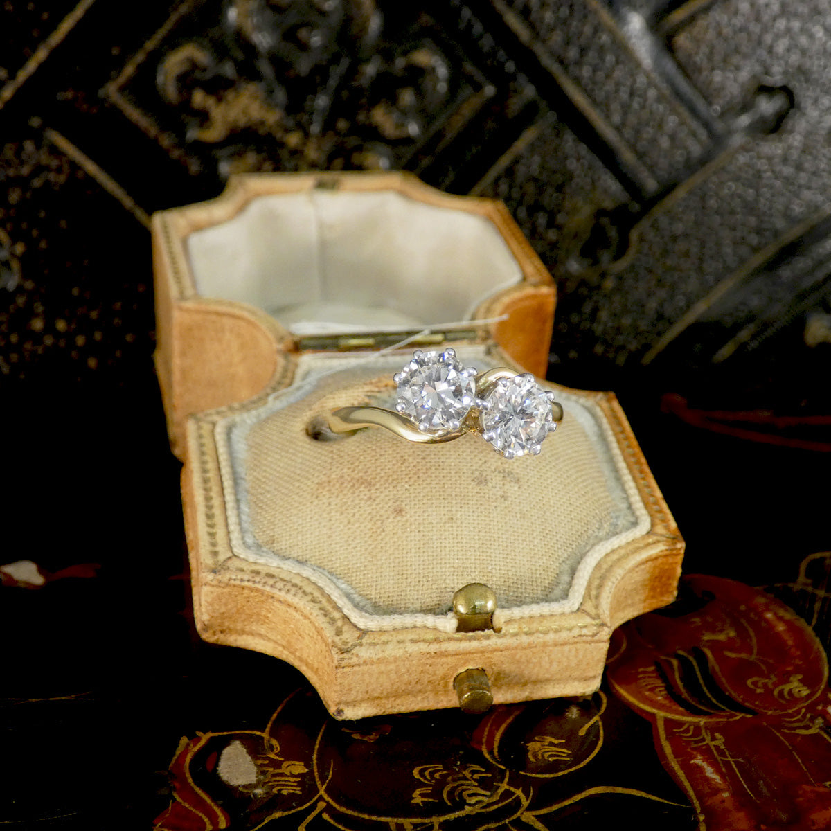 Diamond ring in a decorative jewelry box on an ornate surface
