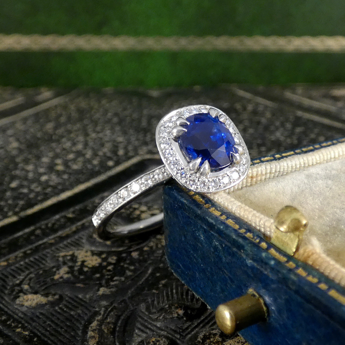 Silver ring with a blue gemstone on an ornate box