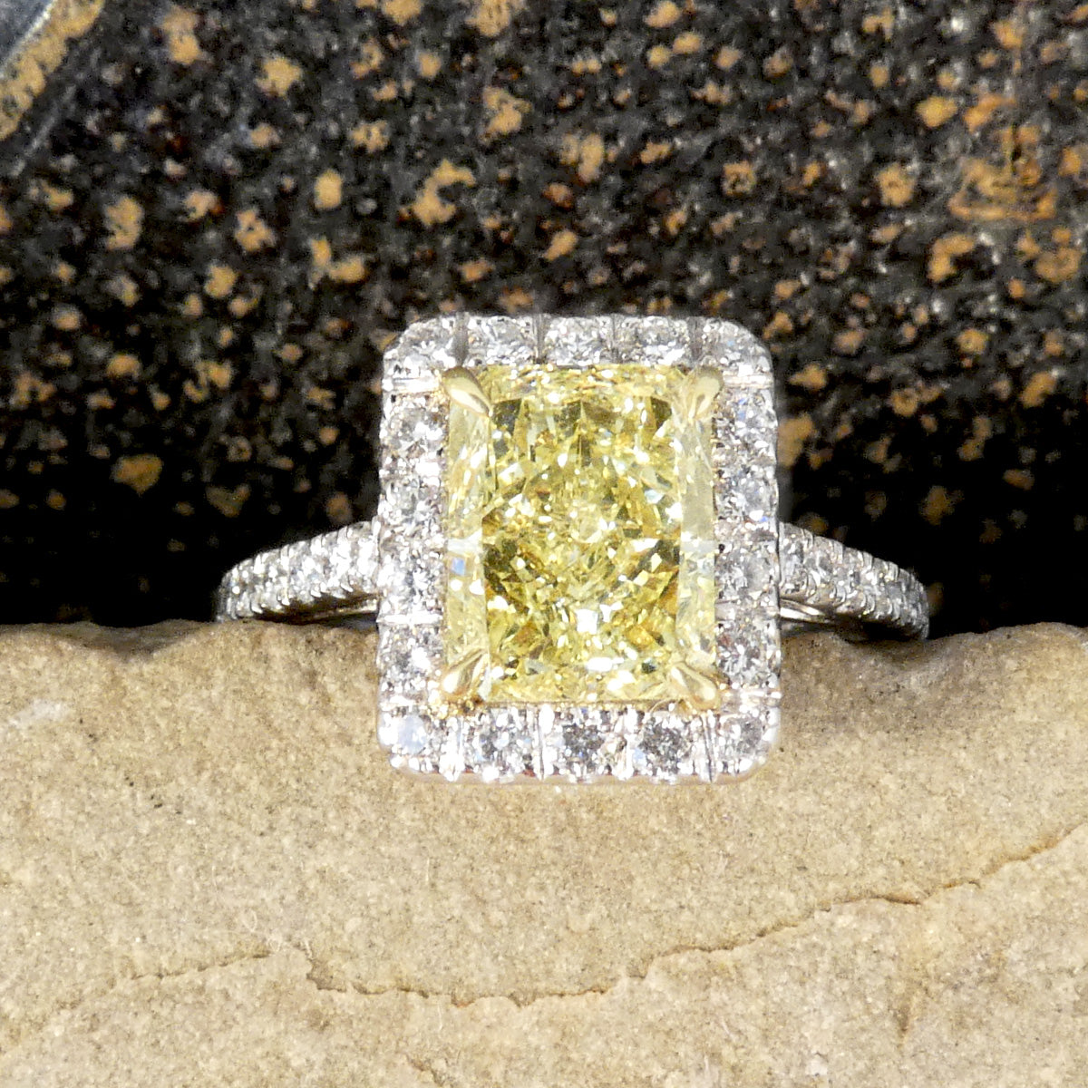 Natural Yellow Radiant Cut Diamond with GIA grading in a four claw setting. Surrounded by a halo of bright white Diamonds and Diamond set shoulders in 18ct White Gold. Perfect engagement ring with bright yellow diamond and bright white diamonds.
