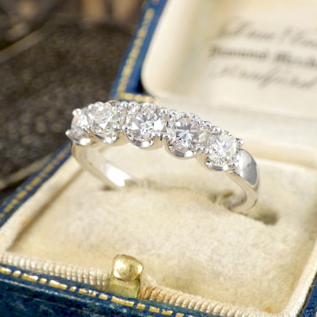 Diamond ring in an open jewelry box with a blurred background
