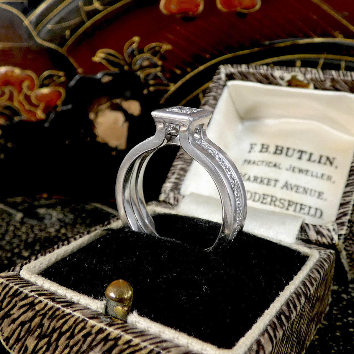 Platinum ring in a jewelry box with 'F.B. Butlin' branding in the background