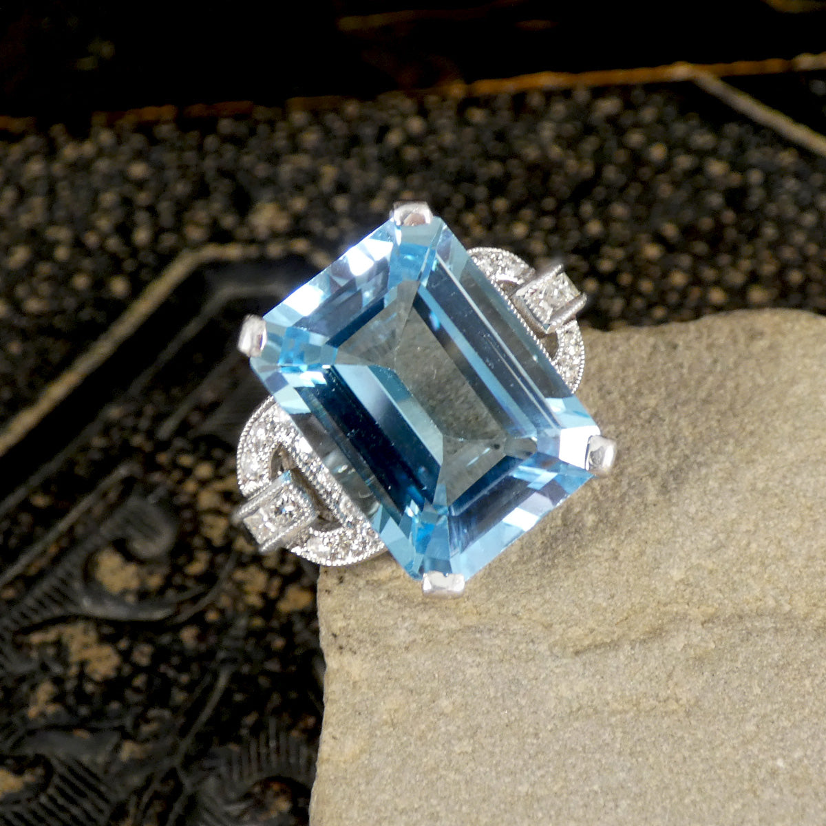Ring with a large blue gemstone on a textured surface