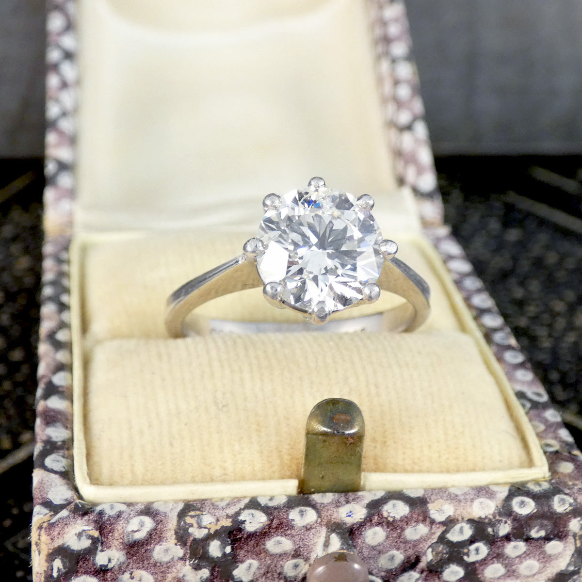 Diamond ring in a jewelry box with a floral pattern