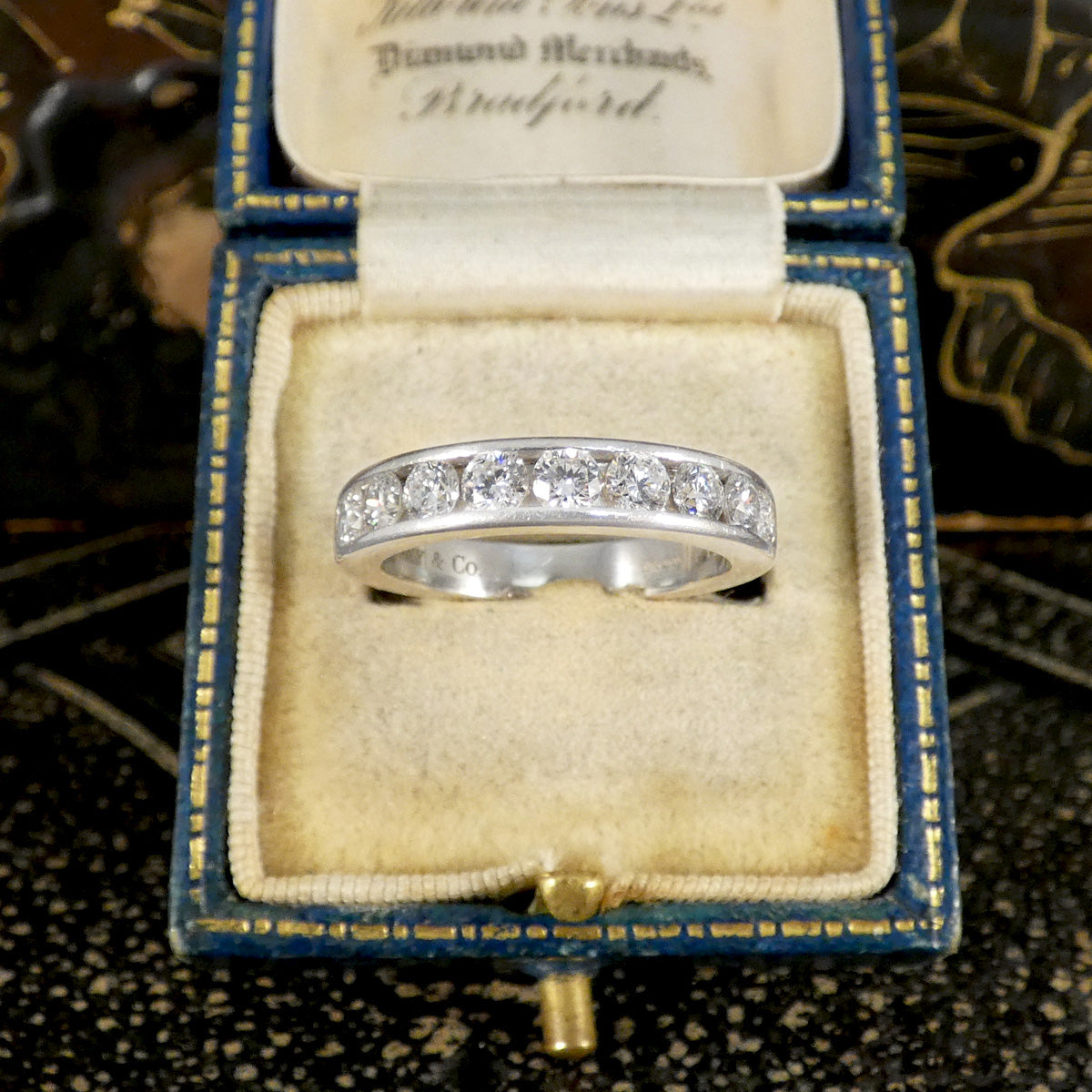 A diamond channel set ring in platinum displayed in jewellery box