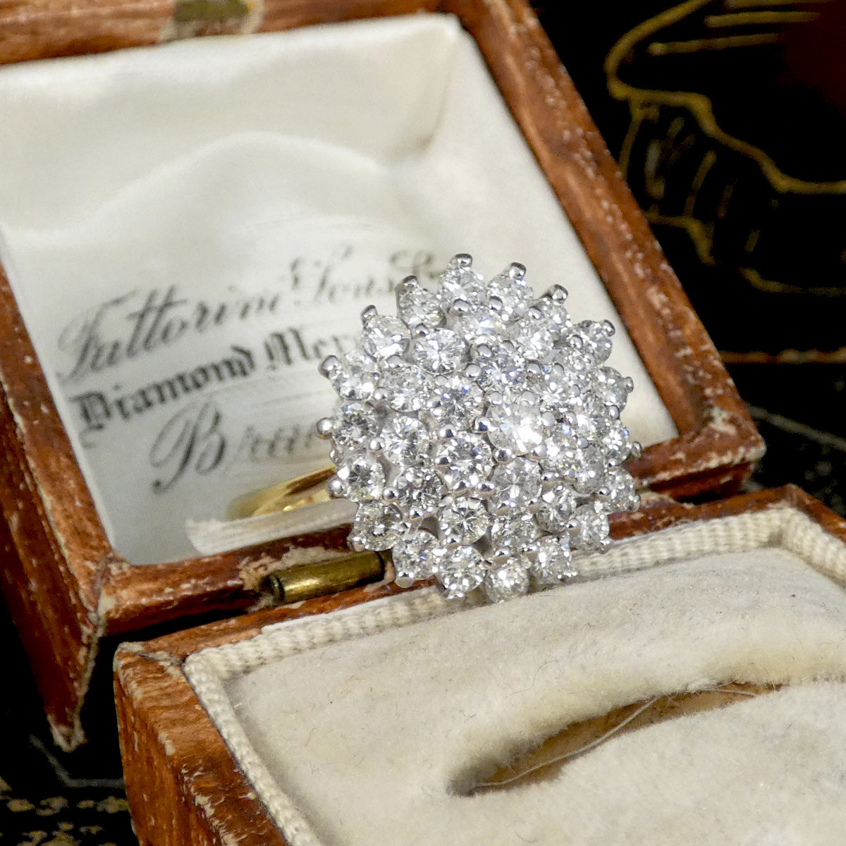 Diamond ring in an open jewelry box with visible branding