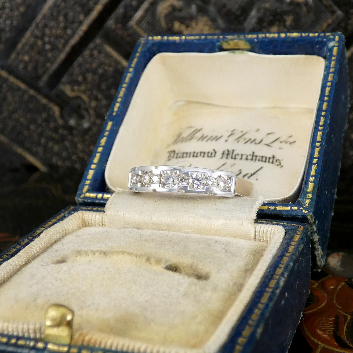 Diamond ring in an open jewelry box with a decorative background