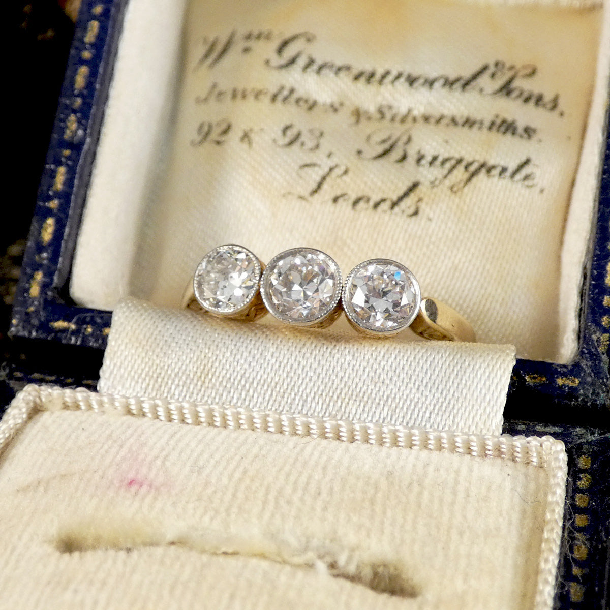 Diamond ring in an antique jewelry box with engraved text