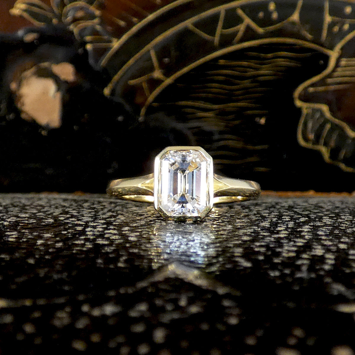 1.55ct Emerald Cut Diamond Solitaire in a Bezel Setting in 18ct Yellow Gold, showcasing a clear and bright diamond graded F/VS. natural diamond.