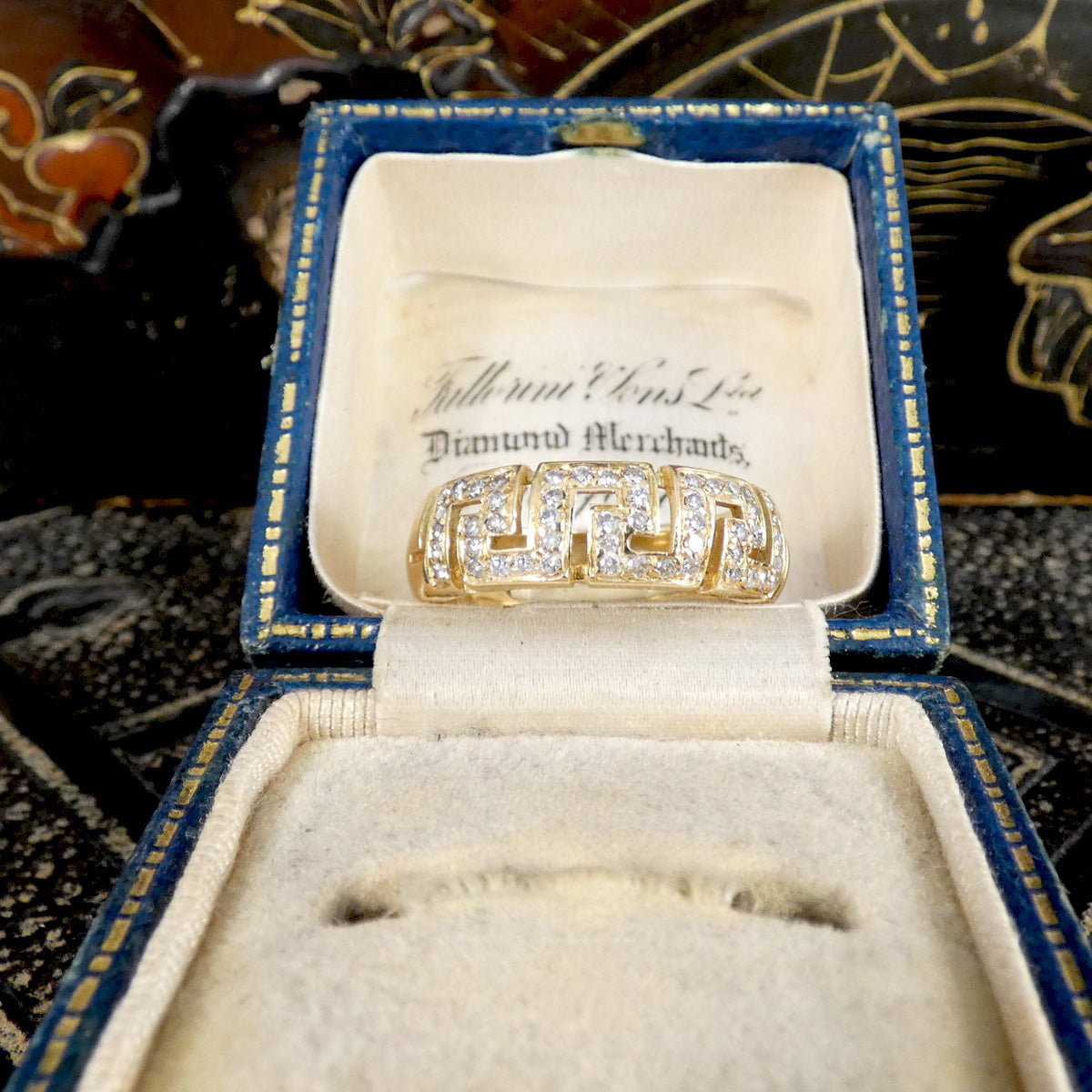 Gold ring with diamonds in a jewelry box on a decorative background