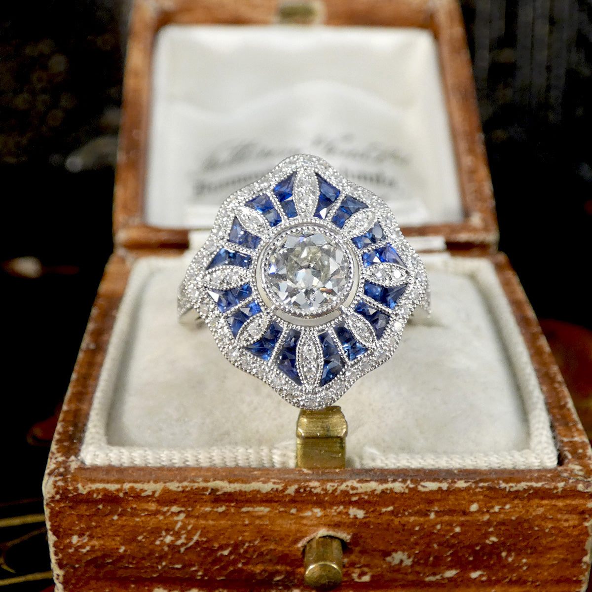 Art Deco Inspired Diamond and Sapphire Cluster Ring in Platinum displayed in vintage box.