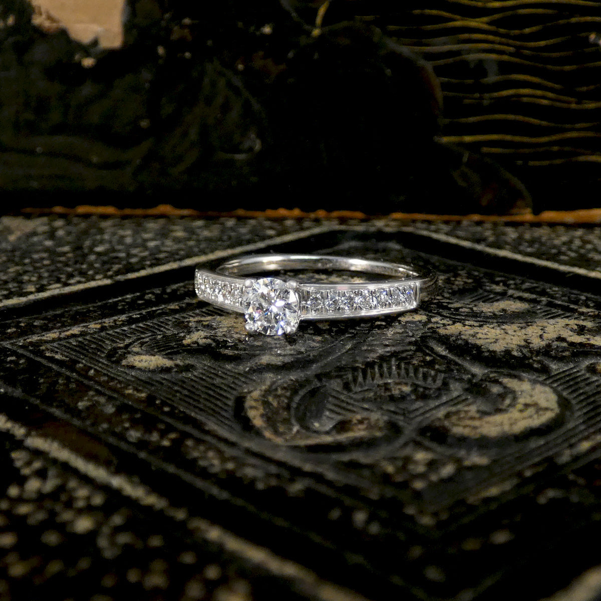 Diamond ring on an ornate black and gold surface