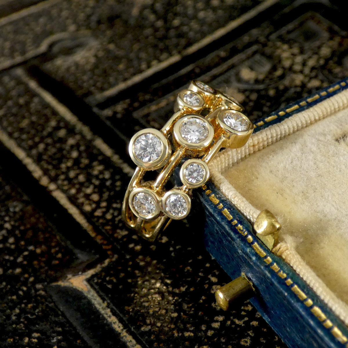 Gold ring with diamonds on a textured surface