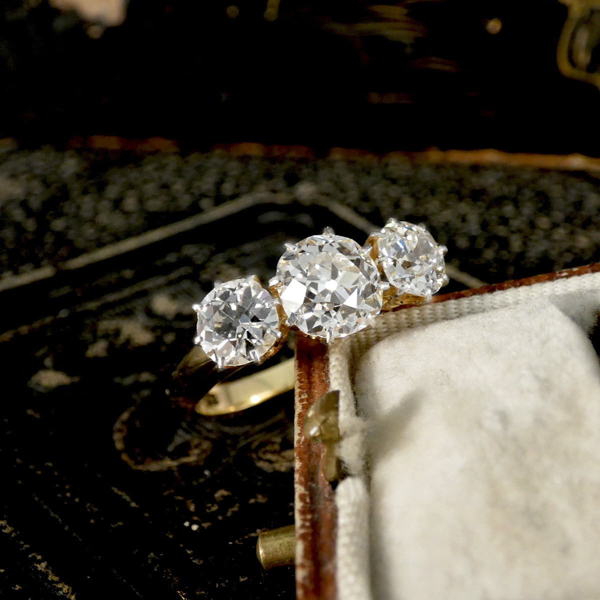 Gold ring with three diamonds in a jewelry box