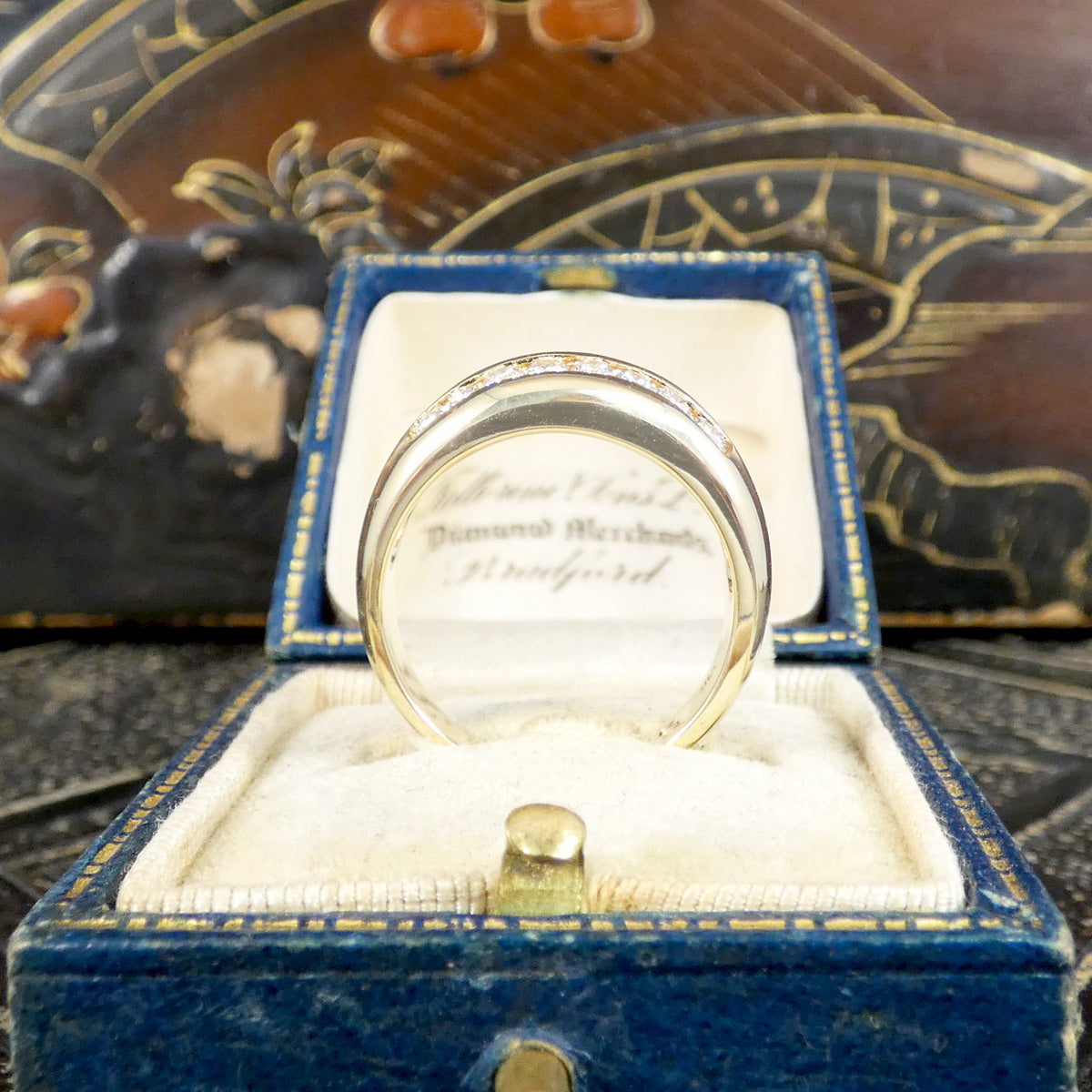 A channel set diamond double row ring in yellow gold shown from the side to see the comfort wear.